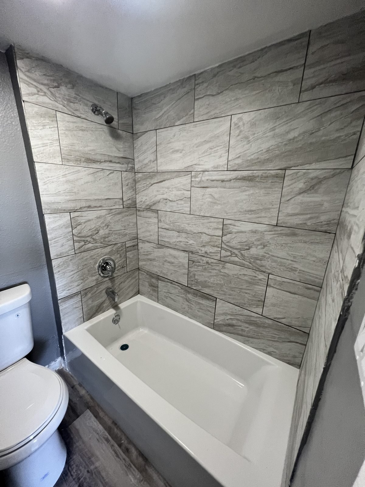 Bathroom after: tiled tub surround and new fixtures