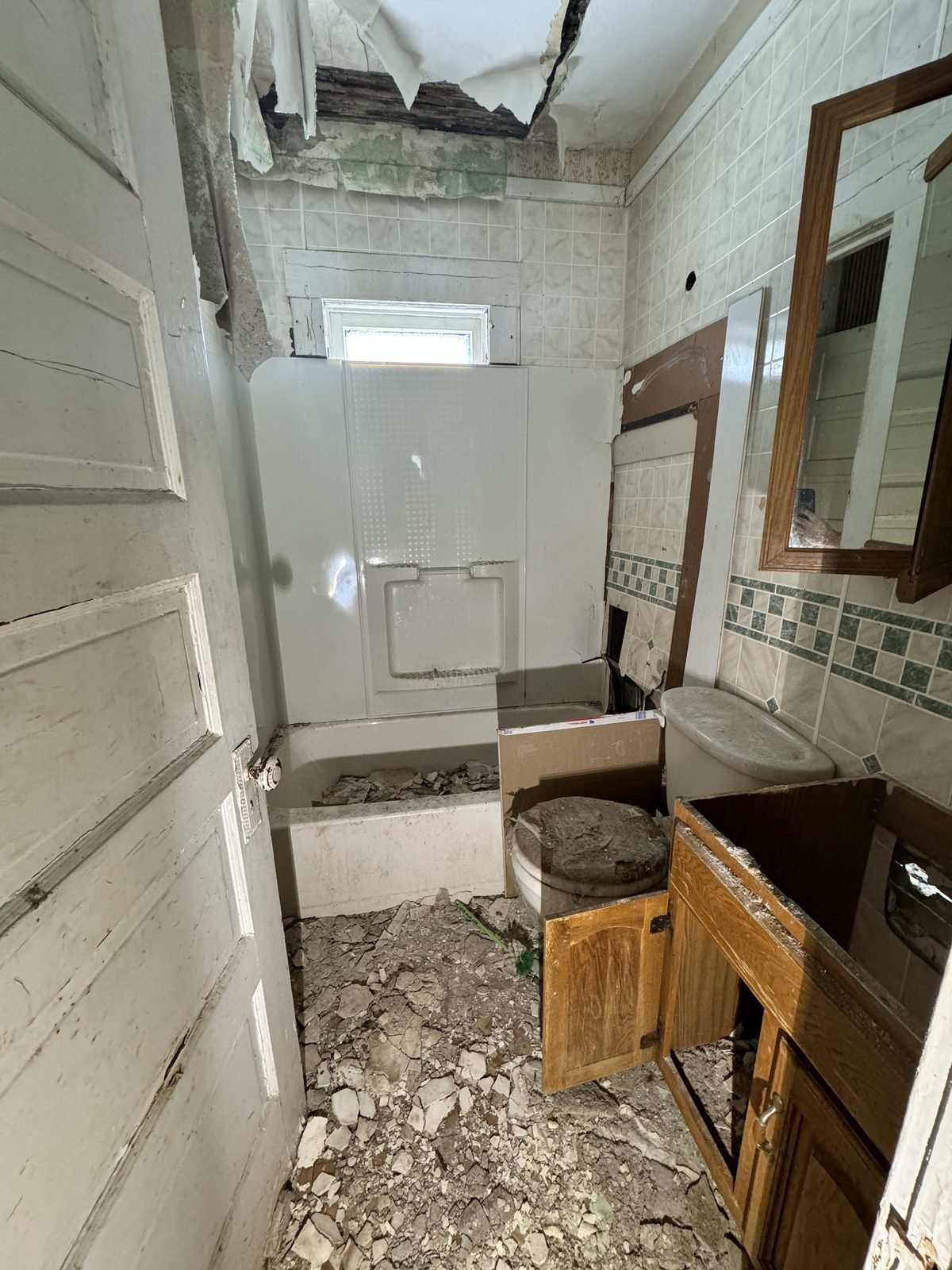 Kitchen before: gutted, debris on the floor, ceiling open