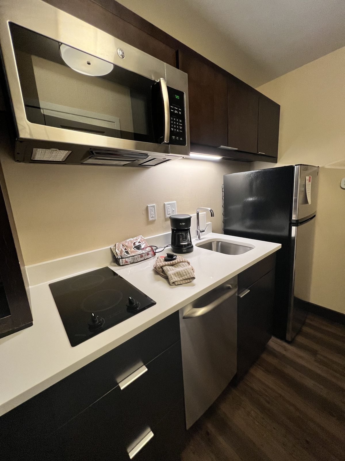 Kitchen after: dark cabinets, stainless appliances, quartz counter